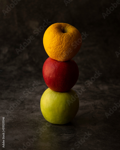 three apples, yellow, red and green
