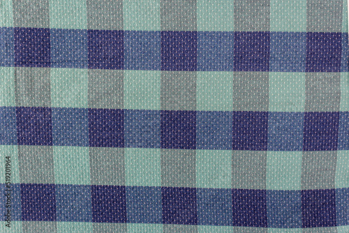 Blue and green cells, the texture of checkered fabric as a background. Fabric shirt in a cage. Repetitive geometric pattern with intersecting lines, squares. Abstract pattern.