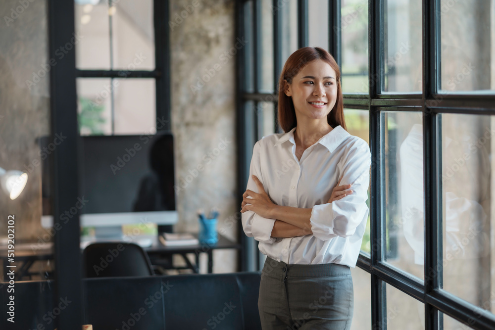 Beautiful Asian businesswoman standing with her arms crossed and confidently looking at the camera in the office. Beautiful Asian businesswoman standing with her arms crossed and confidently looking at the camera in the office.