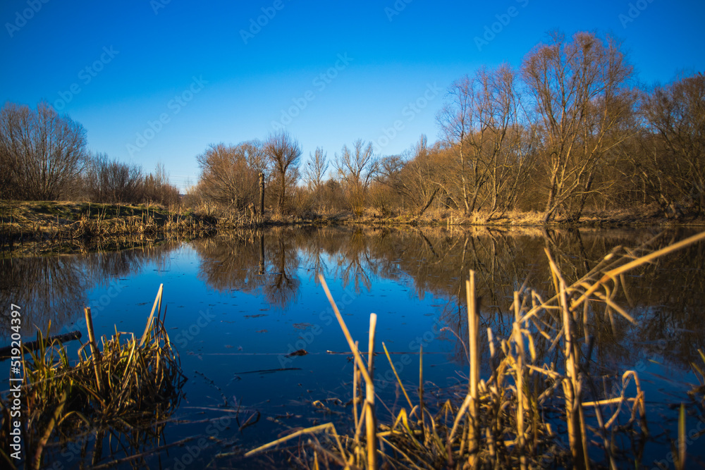 the mirroring of the water level at the confluence of the Vltava and Berounka rivers in Prague's Zbraslav river, which forms the ponds and the Modřana lagoon in Prague. Autumn and trees without leaves the mirroring of the water level at the confluence of the Vltava and Berounka rivers in Prague's Zbraslav river, which forms the ponds and the Modřana lagoon in Prague. Autumn and trees without leaves