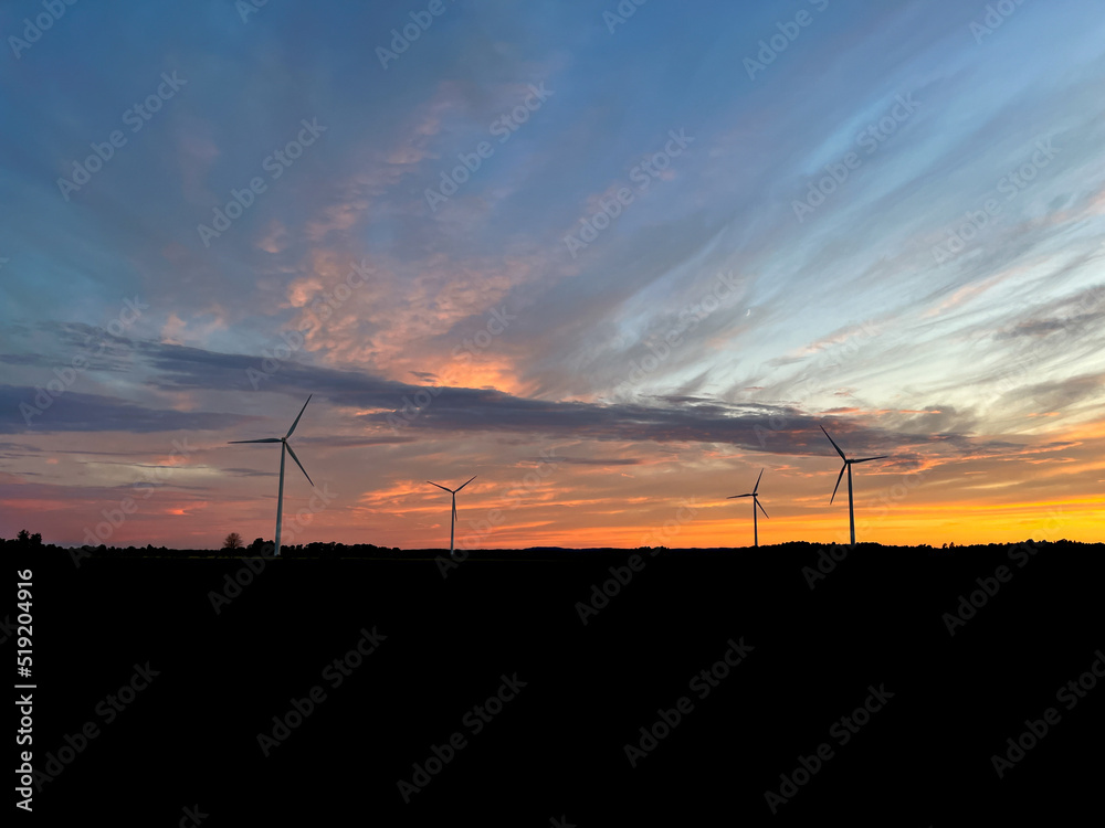 Orange sunset with purple cloud in the landscape, black silhouette of the windmills Orange sunset with purple cloud in the landscape, black silhouette of the windmills
