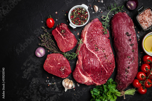 beef meat background fillet steaks with herbs and spices on a dark background. Restaurant menu, dieting, cookbook recipe top view