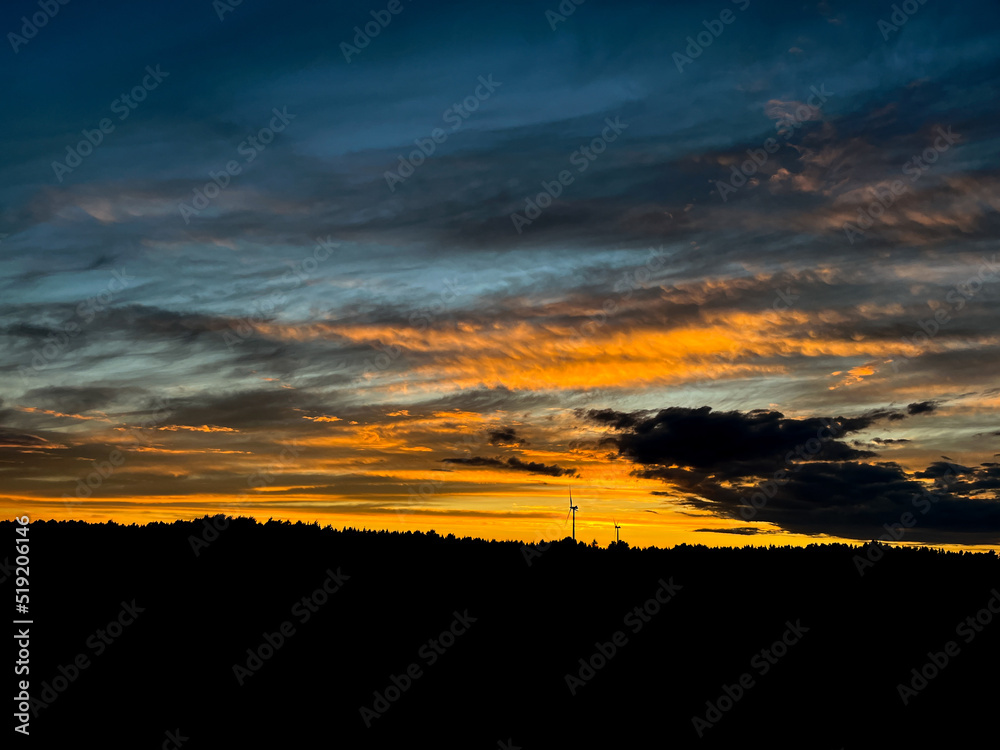 Orange sunset with purple cloud in the landscape, black silhouette of the windmills Orange sunset with purple cloud in the landscape, black silhouette of the windmills