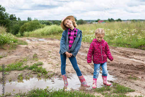 Two girls run through the puddles and play.