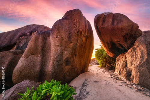 Granite rocks in pink sunset on La Digue island in Seychelles photo