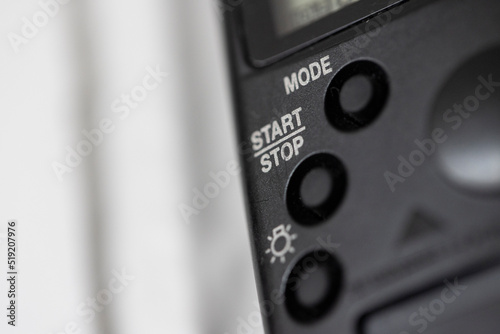 Obraz na plátně A part of a camera shutter release remote with the words start and stop written on it Nr