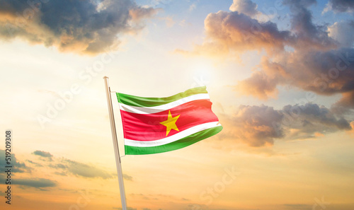 Suriname national flag cloth fabric waving on the sky - Image photo