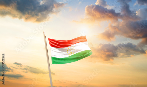 Tajikistan national flag cloth fabric waving on the sky - Image
