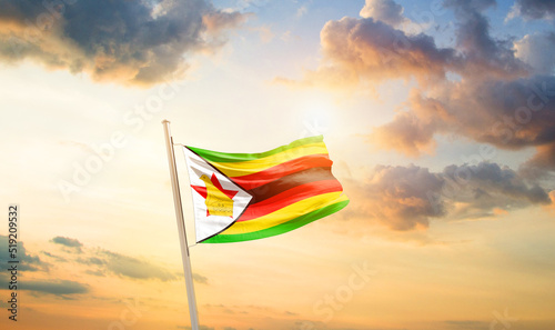 Zimbabwe national flag cloth fabric waving on the sky - Image
