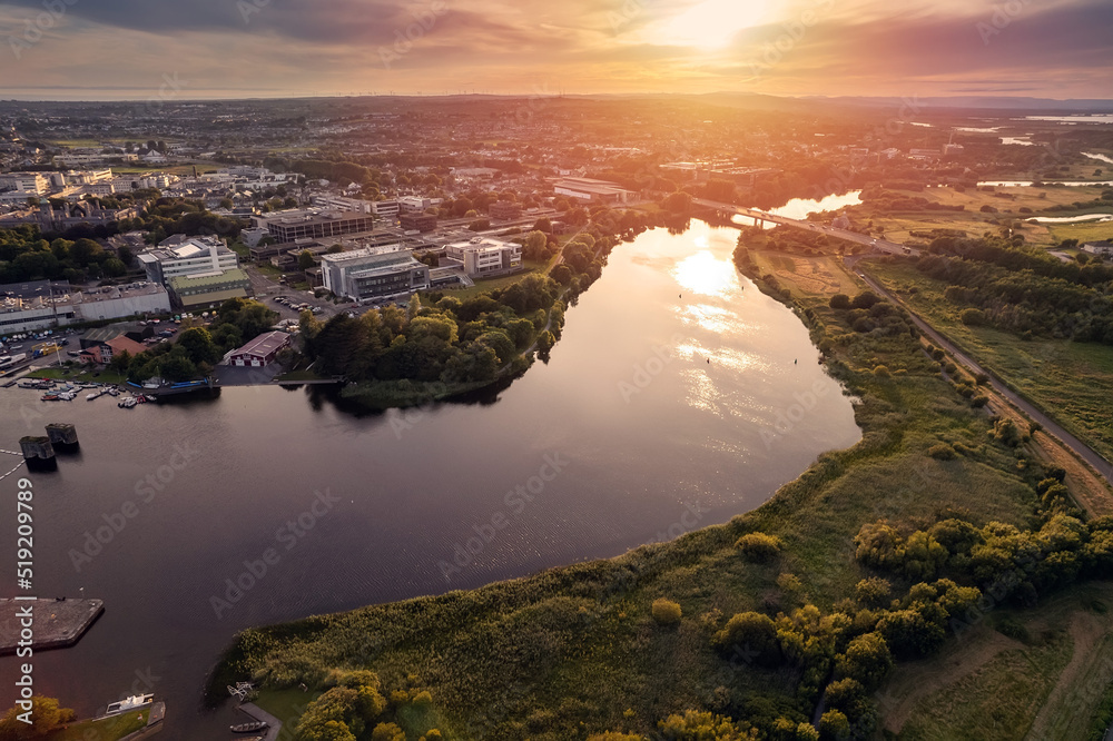 Aerial view on river Corrib. Dusk sunset time. . Warm and cool color tone. Sun flare. Calm and peaceful atmosphere. Galway city, Ireland. Nature landscape.