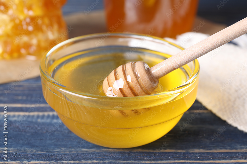 Fototapeta premium Tasty fresh honey on blue wooden table