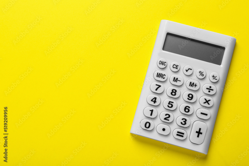 White calculator on yellow background, top view. Space for text