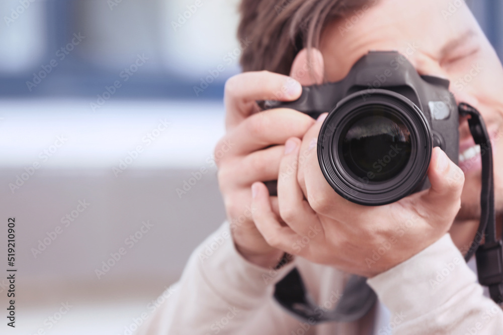 Professional photographer with camera on blurred background. Space for text