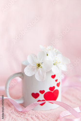 valentine s day concept. white cup for coffee with hearts on a pale pink background 