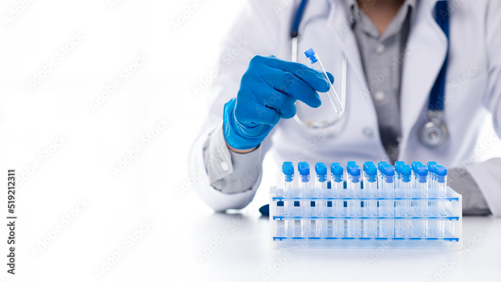 A laboratory assistant, a medical scientist, a chemistry researcher holds a test tube of chemicals and examines the disease from a patient's blood sample. Medicine and research concept.