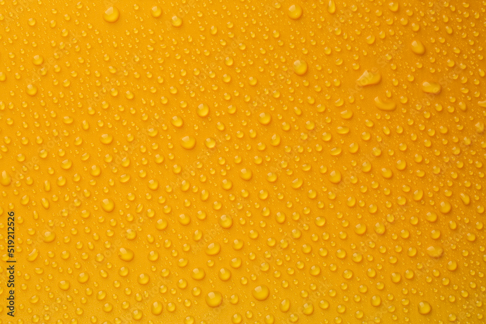 Water drops on orange background, top view Water drops on orange background, top view