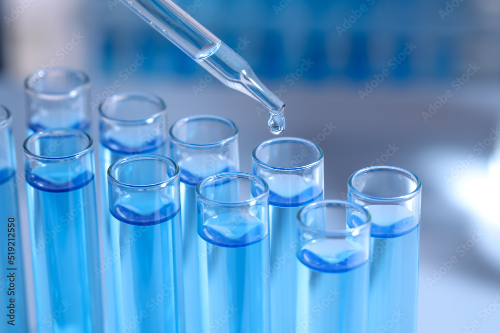 Dripping reagent into test tube on blurred background, closeup. Laboratory analysis Dripping reagent into test tube on blurred background, closeup. Laboratory analysis