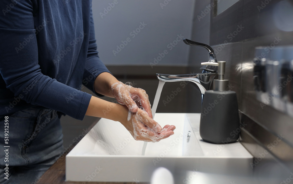 Woman washing hands in bathroom, closeup view