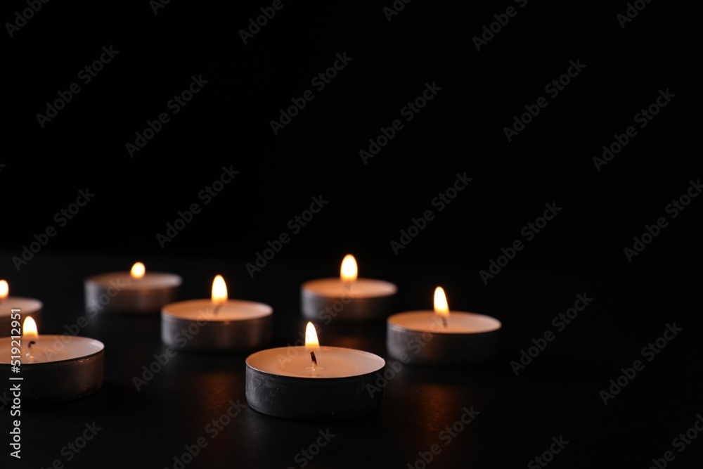 Burning candles on black background, space for text. Holocaust memory day Burning candles on black background, space for text. Holocaust memory day