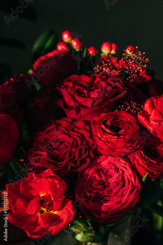 Bright red flowers bouquet on dark background. 