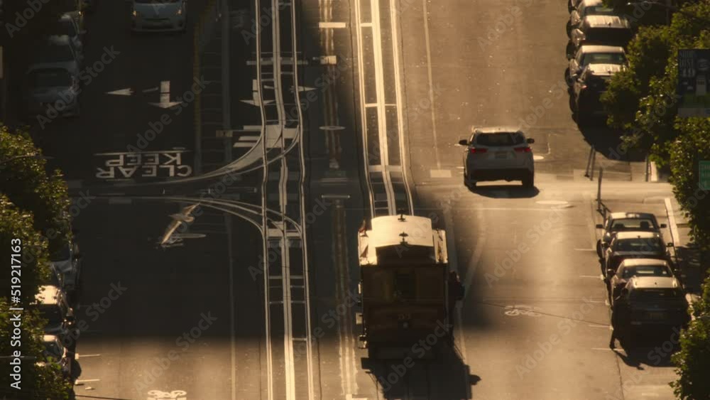 San Francisco tram shot. City street vehicle roads sunset, commuter moving traffic at sunrise city. Urban street road cable car slow motion. Empty city on early morning.Transport moving slowly on road