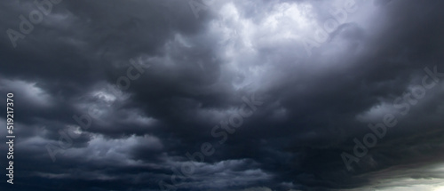 The dark sky with heavy clouds converging and a violent storm before the rain.Bad or moody weather sky and environment. carbon dioxide emissions, greenhouse effect, global warming, climate change.