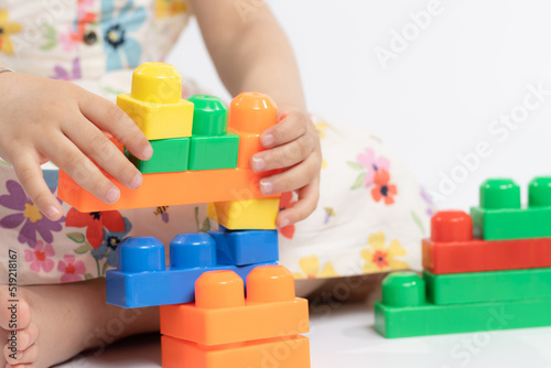 Close up of kids's hands playing with colorful building blocks connector toys on the floor. Educational toys for preschool kindergarten child. Fun, Activity, Learning, School, Nursery, Daycare Concept