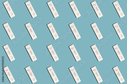 Positive Covid-19 antigen test pattern on light blue background with harsh shadows
