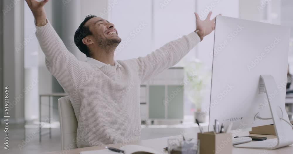 Financial advisor expresses victory and triumph by throwing up work documents in the air and cheers. A happy businessman reads email on a computer and celebrates a promotion at his desk in an office.