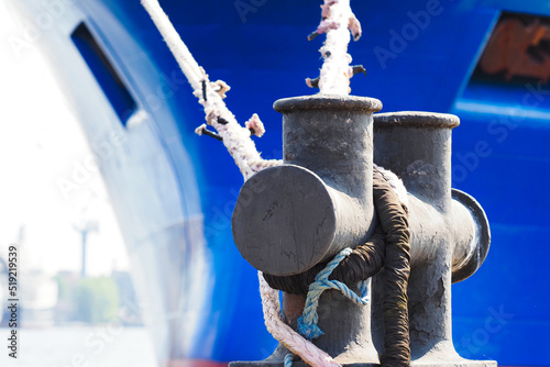 Moored blue ship in marina. Ship moorings bollard close-up photo