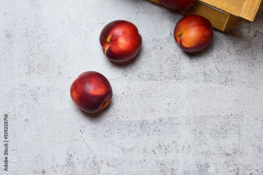 Zenith view, fruit, nectarine on stone background and wooden box, copy space. Zenith view, fruit, nectarine on stone background and wooden box, copy space.