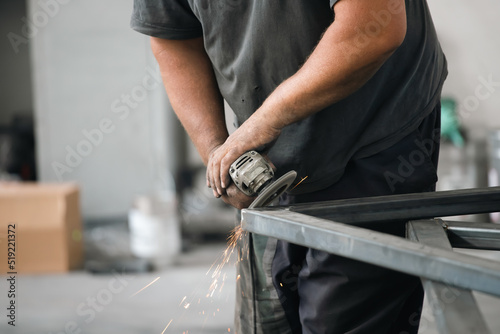 Close up on a man held an angle grinder to cut an iron with sparks