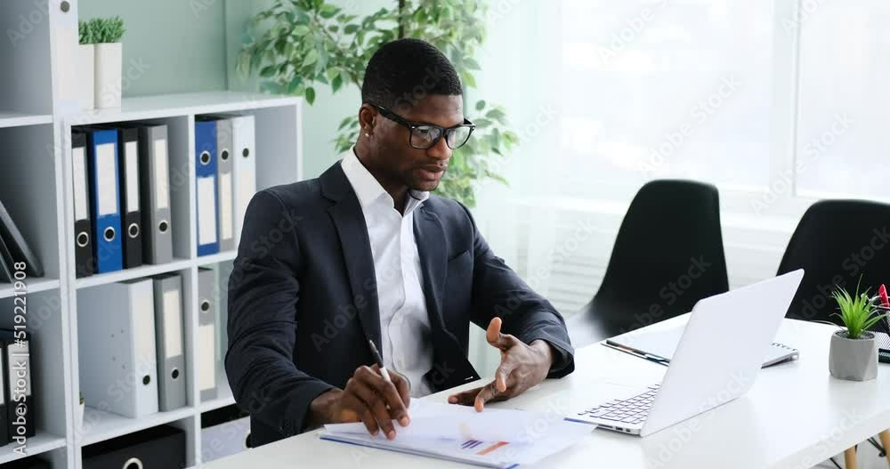 African american businessman engaged in online conference using laptop at office