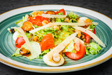 fresh tasty salad with seafood on a black background