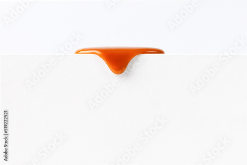 Dripping caramel drops of sweet caramel sauce isolated on white background. Melted caramel sauce drip, drops of sweet liquid toffee.
