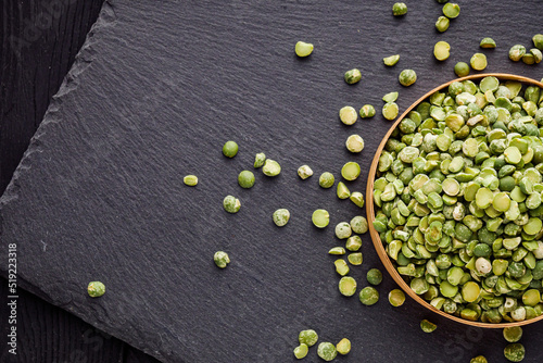 dried green peas on a black stone background