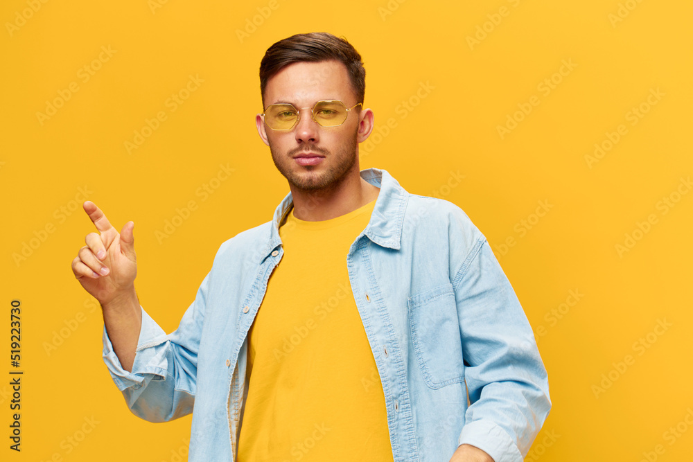 Joyful dancing happy tanned handsome man in blue shirt sunglasses enjoy cool mood posing isolated on orange yellow studio background. Copy space Banner Mockup. Holiday concept Joyful dancing happy tanned handsome man in blue shirt sunglasses enjoy cool mood posing isolated on orange yellow studio background. Copy space Banner Mockup. Holiday concept