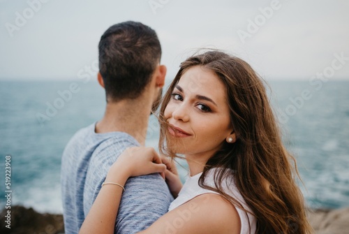 A girl is keeping her hands on the shoulder of her boyfriend on the rocky hill © Roman Tyukin