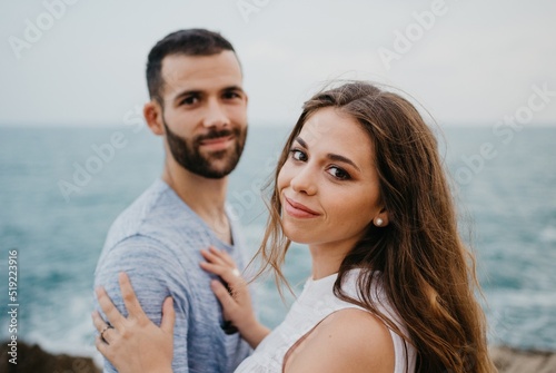 A girl is keeping her hands on the shoulder of her boyfriend on the rocky hill
