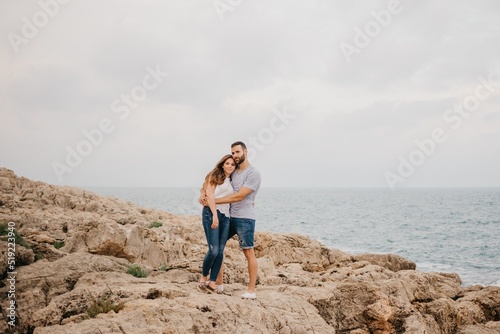 Obraz na płótnie A man and his girlfriend are hugging on the rocky sea coast in Spain w salonie