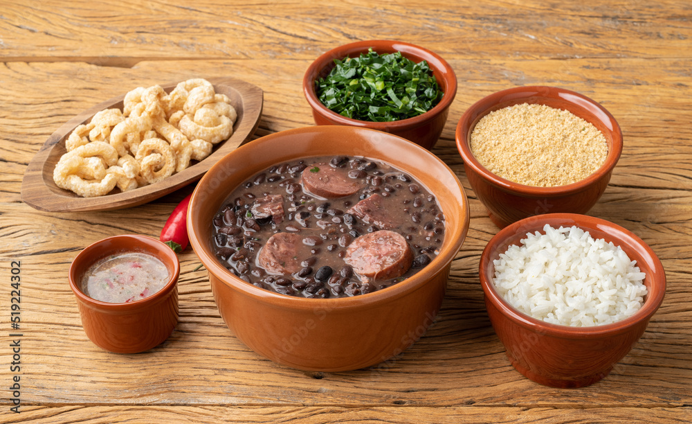 Typical brazilian feijoada with rice, kale, farofa and cracklings Typical brazilian feijoada with rice, kale, farofa and cracklings