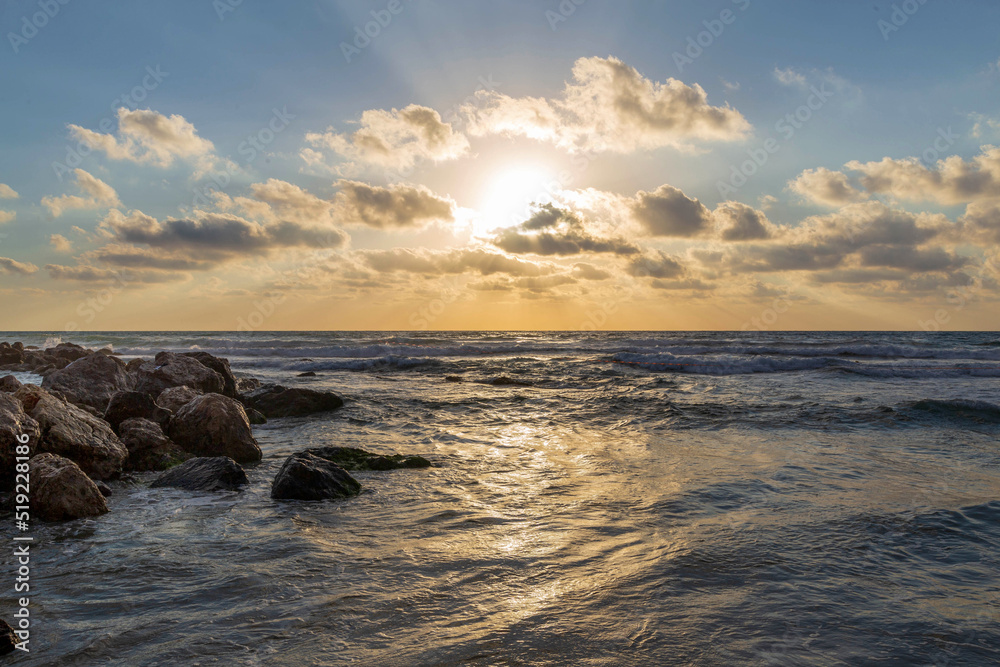 Obraz premium Beautiful summer sunset at the breakwater on the Mediterranean Sea. Israel.