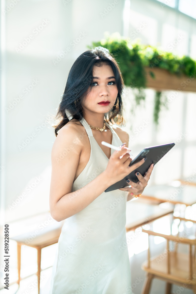 beautiful asian freelance Success people business woman fashion model in summer white sleeveless dress using casual working with tablet for browsing internet, chatting and blogging in coffee shop. beautiful asian freelance Success people business woman fashion model in summer white sleeveless dress using casual working with tablet for browsing internet, chatting and blogging in coffee shop.