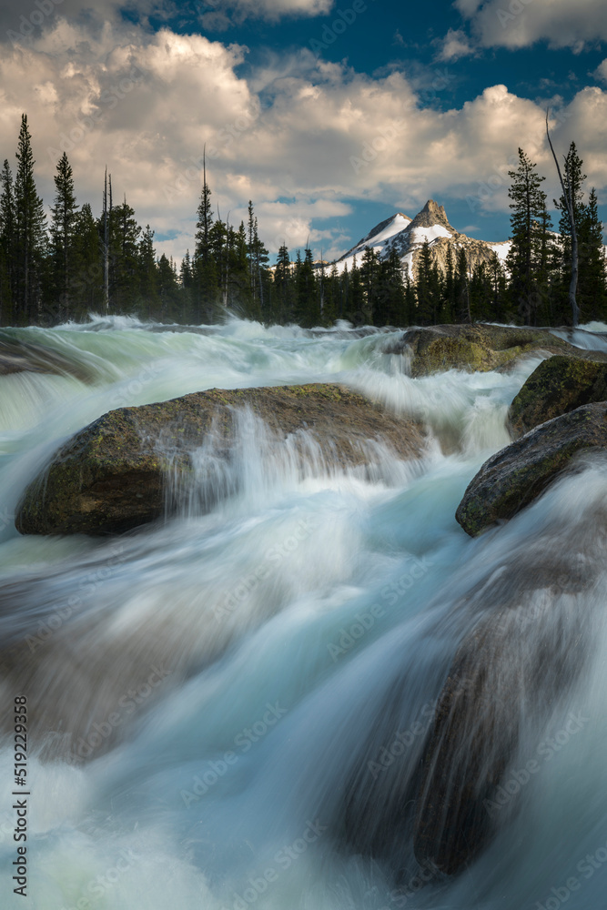 High in the Yosemite back country, the Tuolumne River rages down rocky rapids in spring with Cathedral Peak in the distance. California, USA. High in the Yosemite back country, the Tuolumne River rages down rocky rapids in spring with Cathedral Peak in the distance. California, USA.