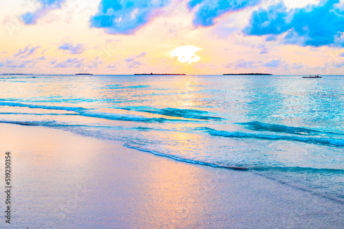 picturesque sunrise in the Maldives island, the sun rising from the Indian ocean and reflected in the water, travel concept