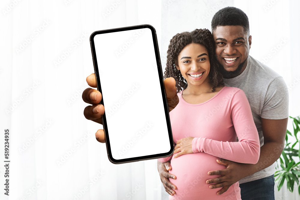Cheerful african american expecting showing smartphone with empty screen