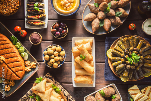 Arabic Cuisine;  Middle Eastern traditional dishes and assorted mezze or meze. Vine leaves, kibbeh, spring rolls, sambusak, kibbeh nayyeh, makdous, haloumi cheese, olives, hummus and yogurt salad. photo