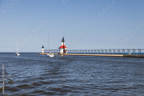 Boats in the channel and St. Joseph North Pier Inner Lighthouse and St. Joseph North Pierhead Outer Lighthouse, Michigan  photo