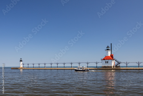 Boat in the channel and St. Joseph North Pier Inner Lighthouse and St. Joseph North Pierhead Outer Lighthouse, Michigan  photo