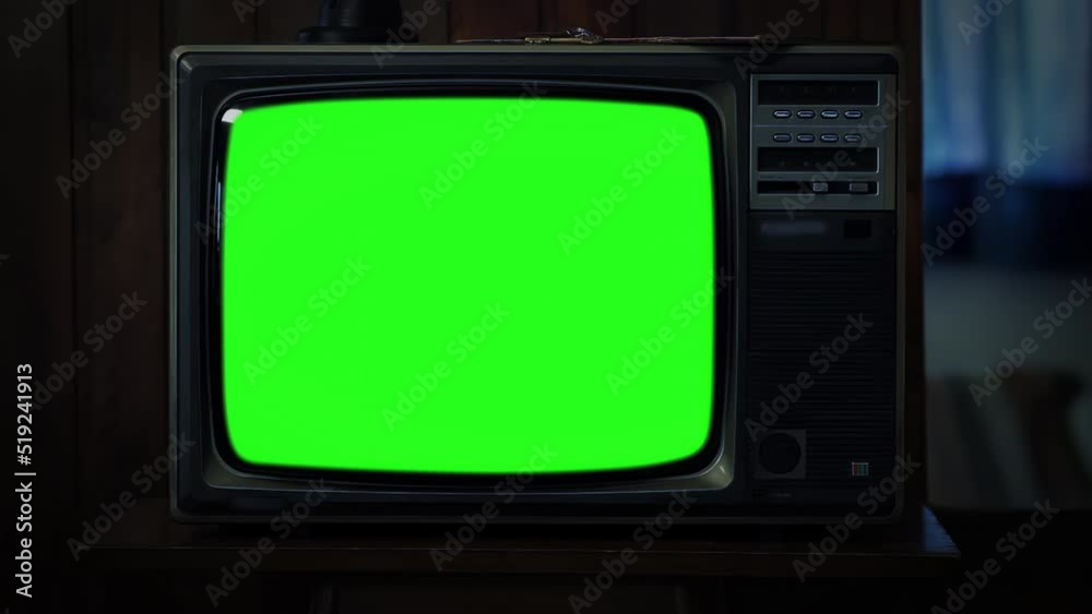 Old Television Set Green Screen in Dark Room. Closeup. Zoom In. You can replace green screen with the footage or picture you want. You can do it with “Keying” effect in After Effects. 4K.